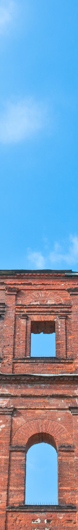 Photo looking up at old wall structure with blue sky above it